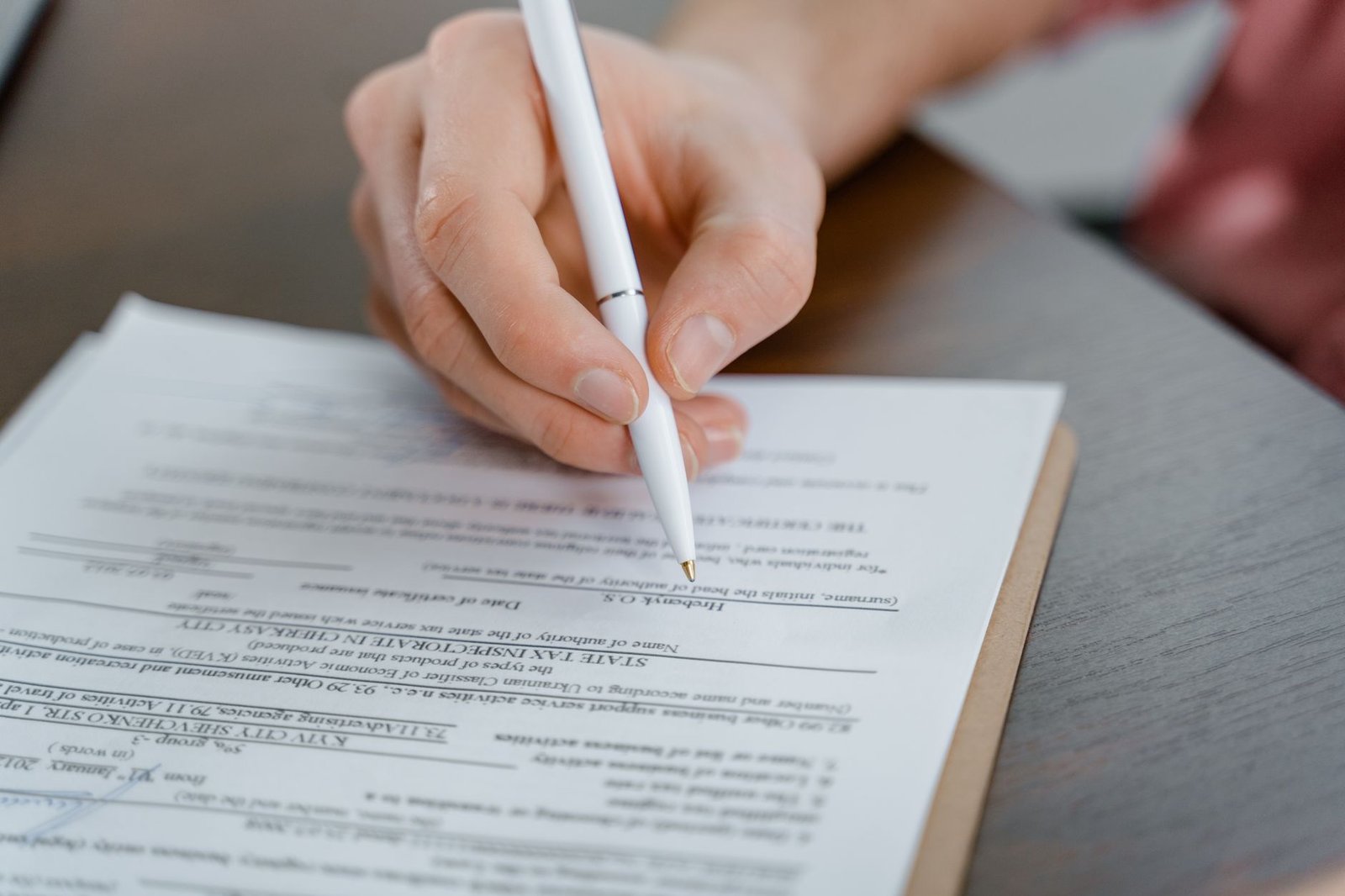 Hands preparing a written motion alleging clear and unmistakable error in a VA decision