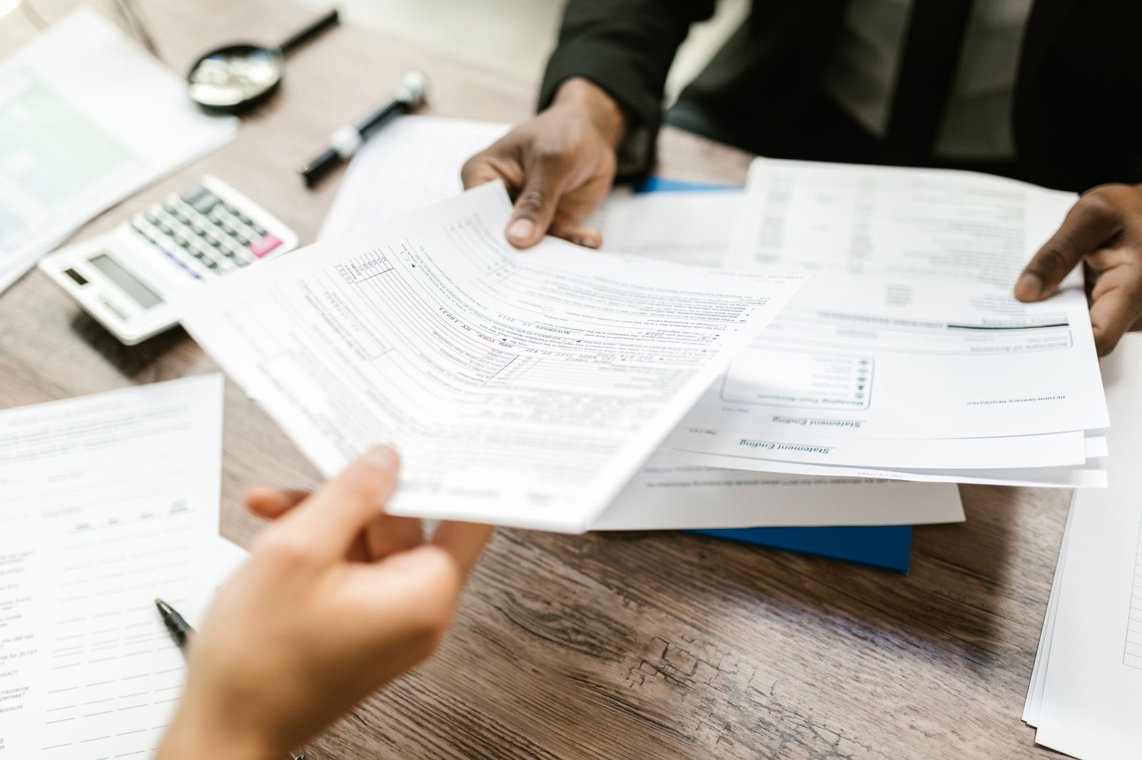 Hands completing application forms related to VA benefits and Medicaid coverage