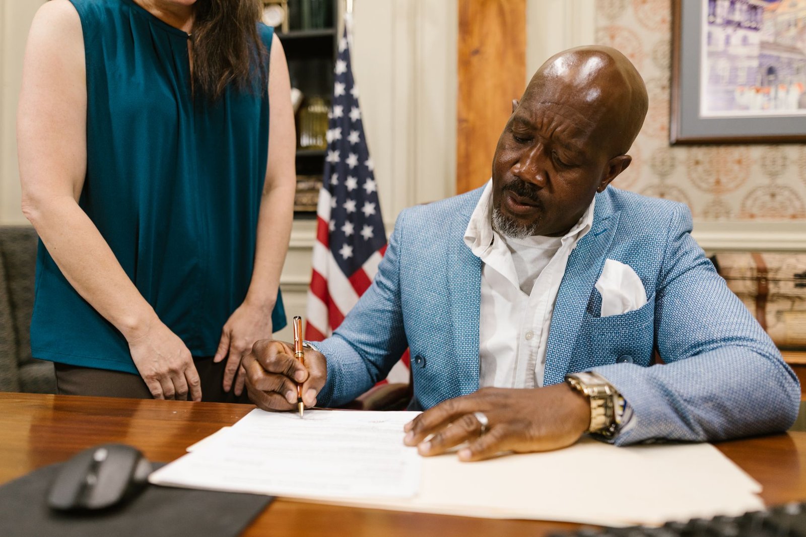 Older veteran signing a VA accredited representative appointment form with a benefits counselor